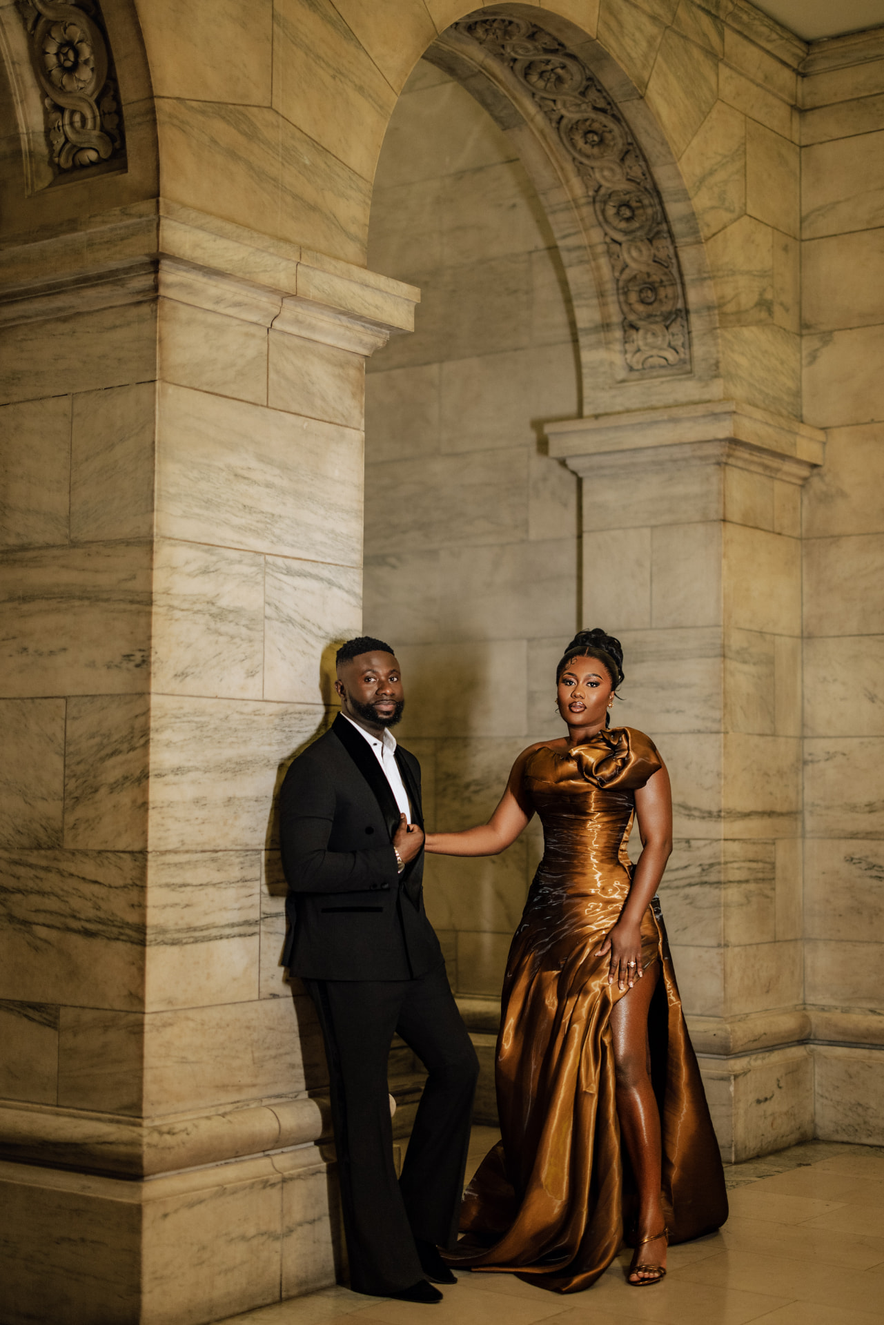 Emmanuel and Priscilla beside the stone pillars